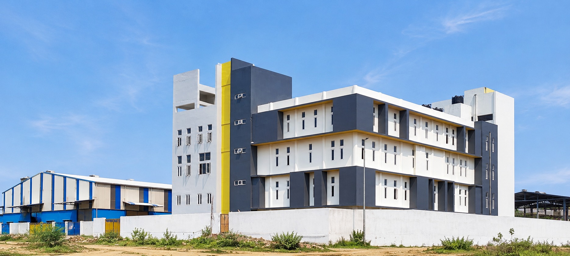 Exterior — the completed building beside the adjoining industrial shed